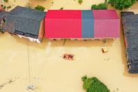 | Photo: Chinatopix Via AP : Rescuers evacuates villagers trapped by floodwaters